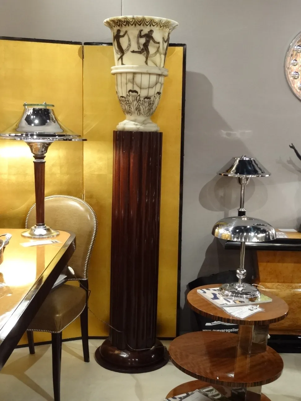 Antica lampada da terra con base elegante e dettaglio decorativo in alto, atmosfera raffinata.