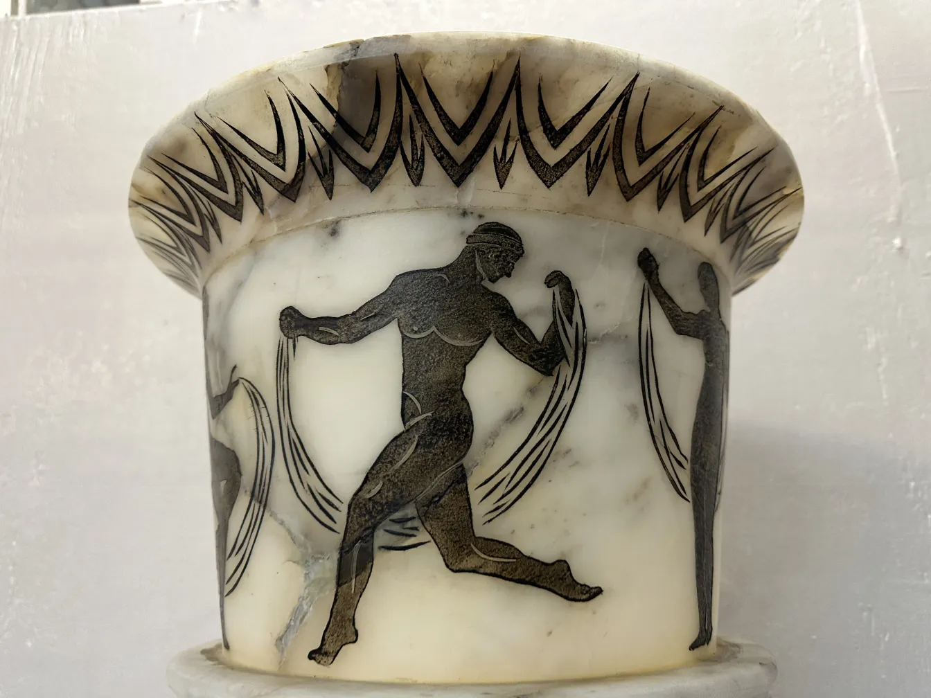 Antigua lámpara de pie con diseños clásicos en la base, decoración intricada.