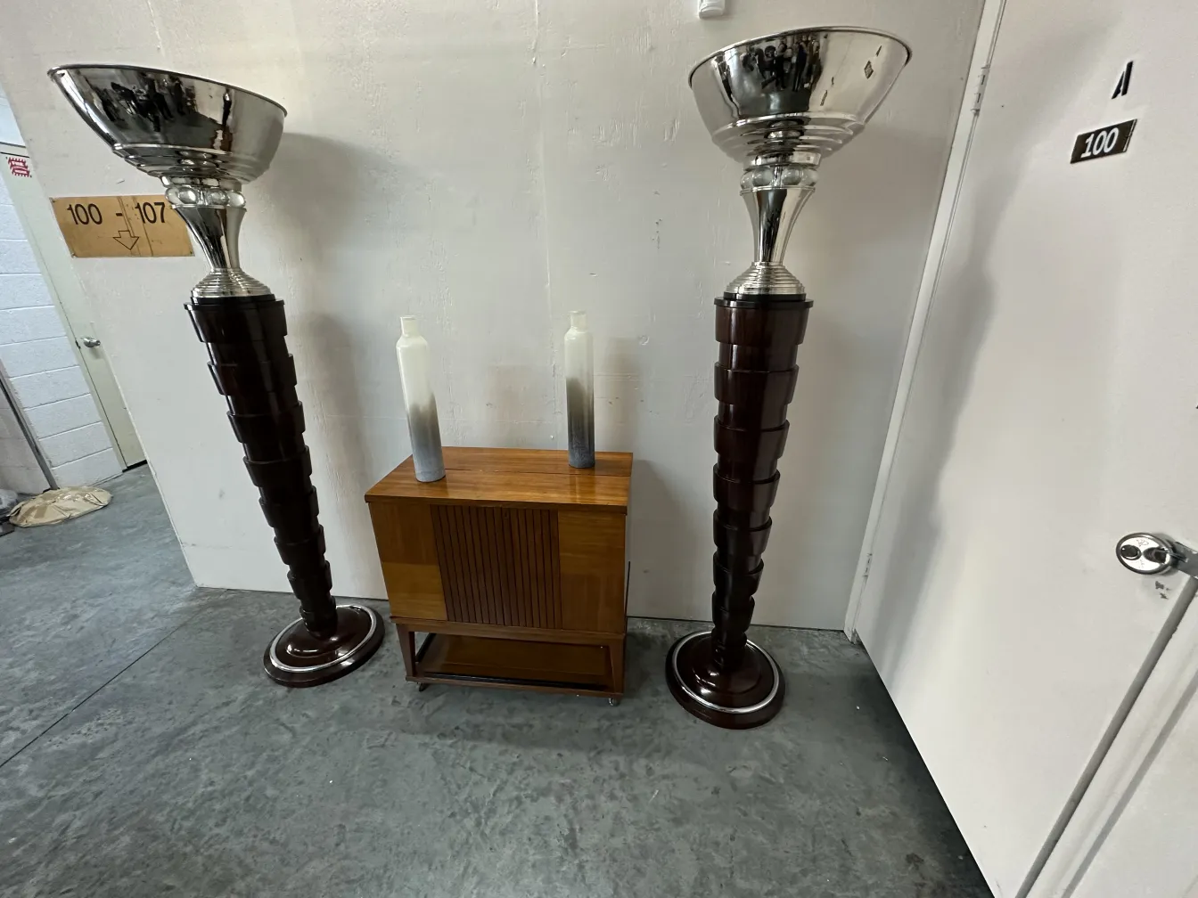 우아한 베이스와 광택 나는 그릇이 있는 2개의 고전 플로어 램프, 현대적 환경에 배치되어 있습니다。