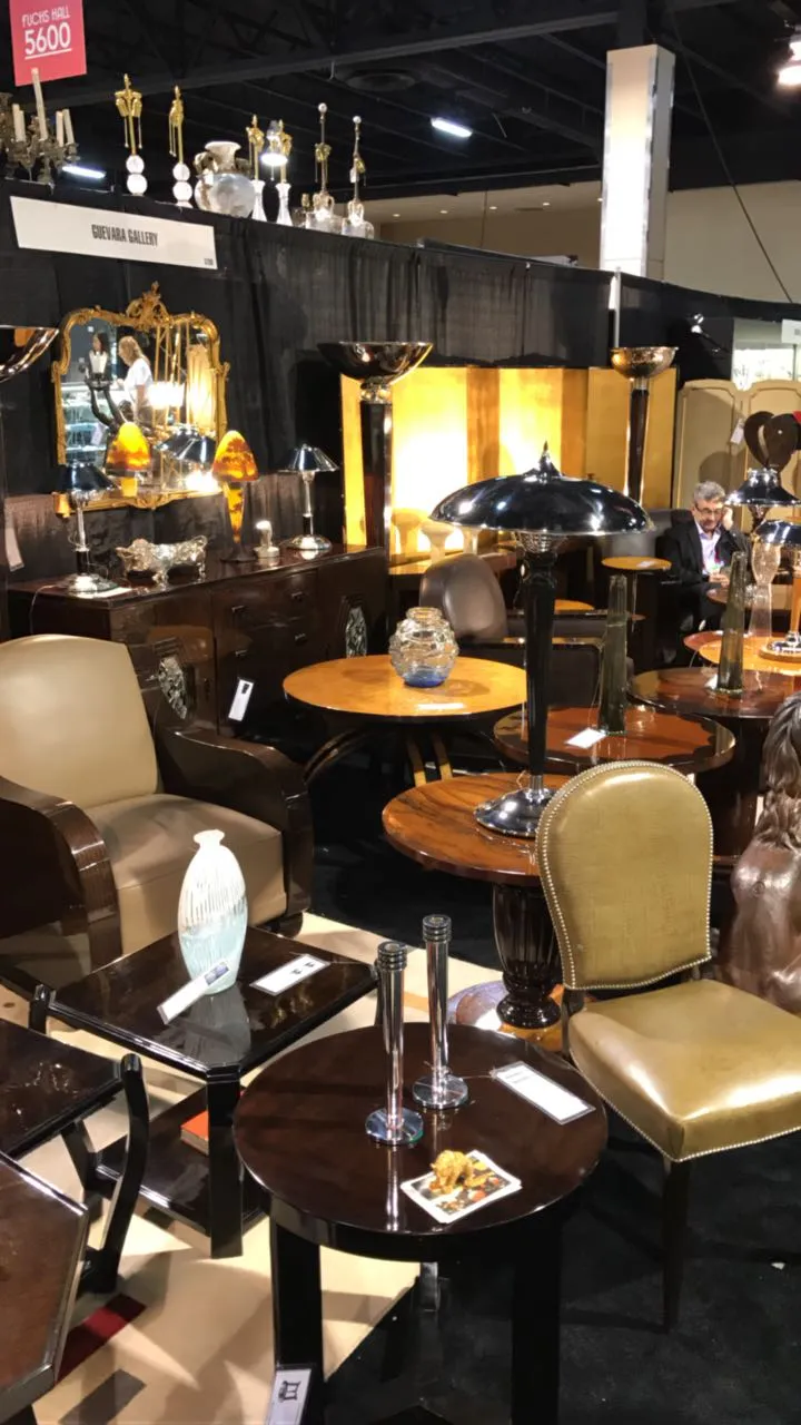 Lampade da terra antiche esposte in un ambiente elegante con tavoli di legno e decorazioni.