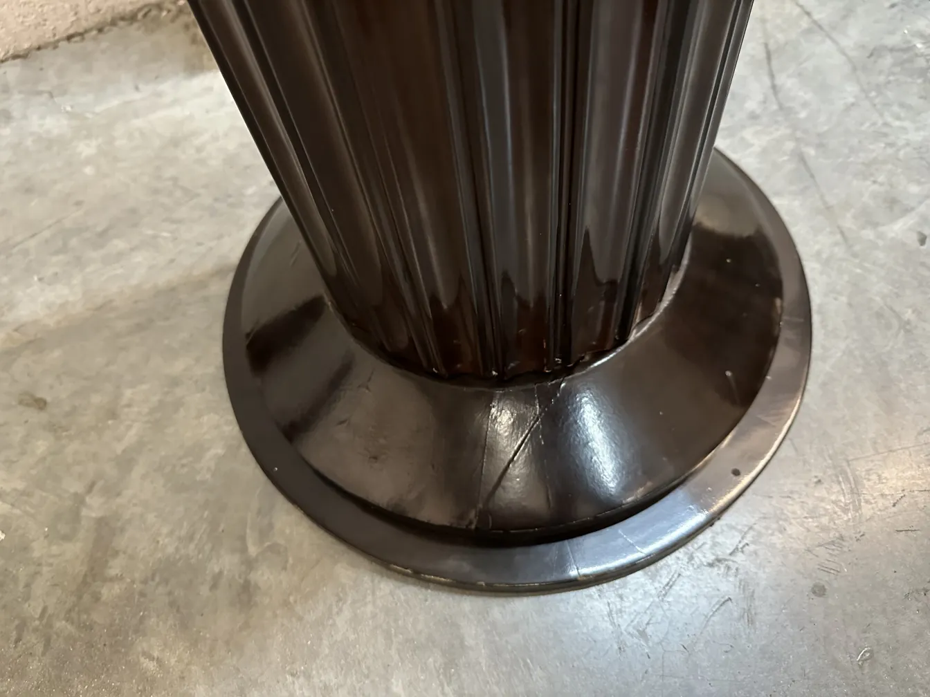 Detalhes de 2 lampadas de piso antigas com base larga e design distinto em um ambiente neutro