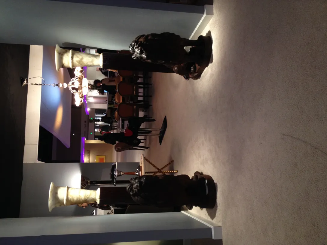 two antique floor lamps, one on each side, in an elegant setting with chairs and table in the background