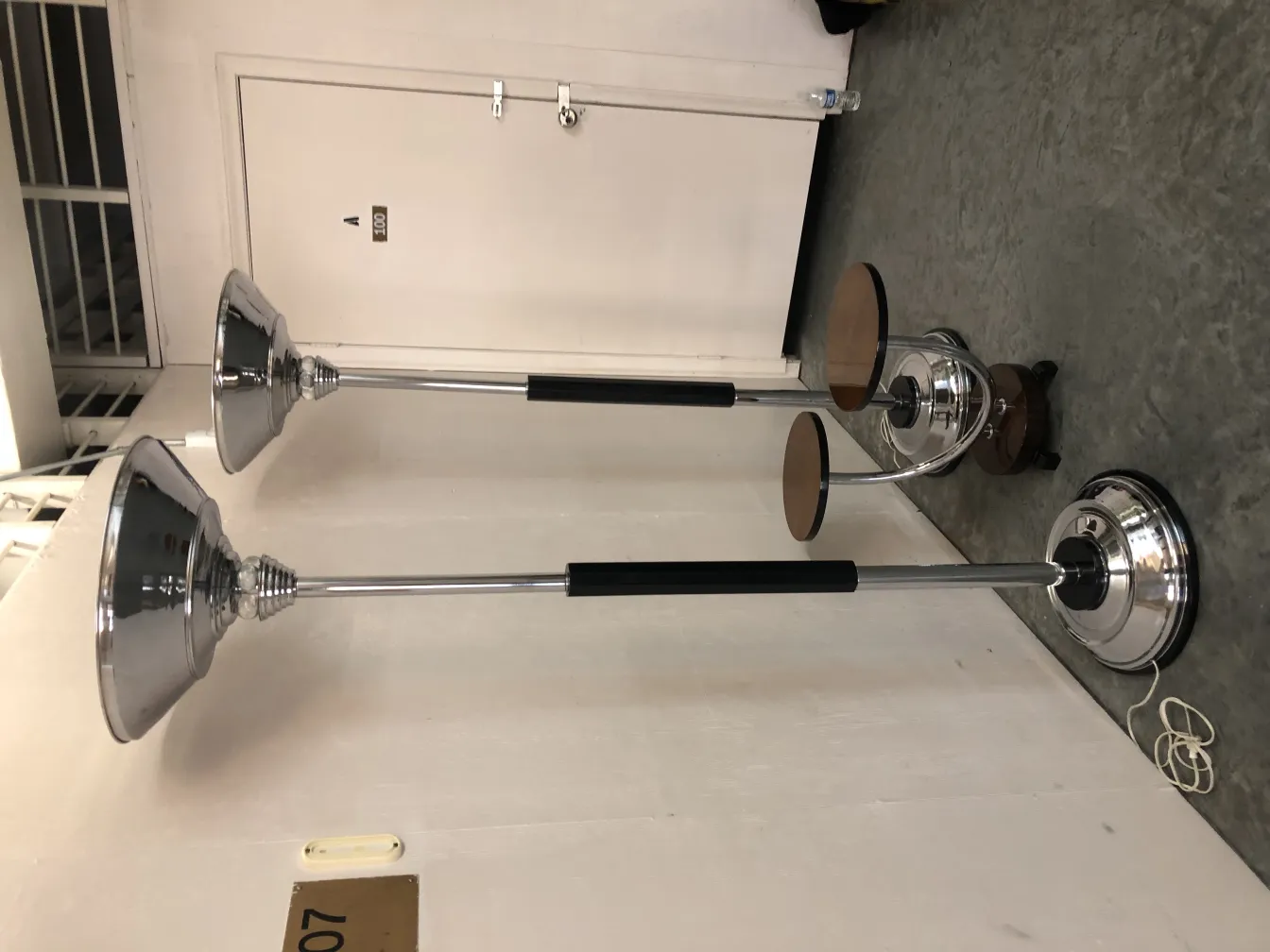 Duas lâmpadas de piso antigas com designs elegantes e bases cromadas.