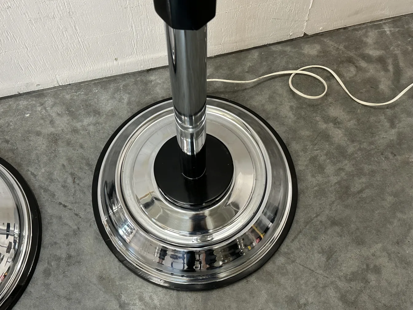 Dos lámparas de pie antiguas con bases redondas cromadas en un ambiente moderno