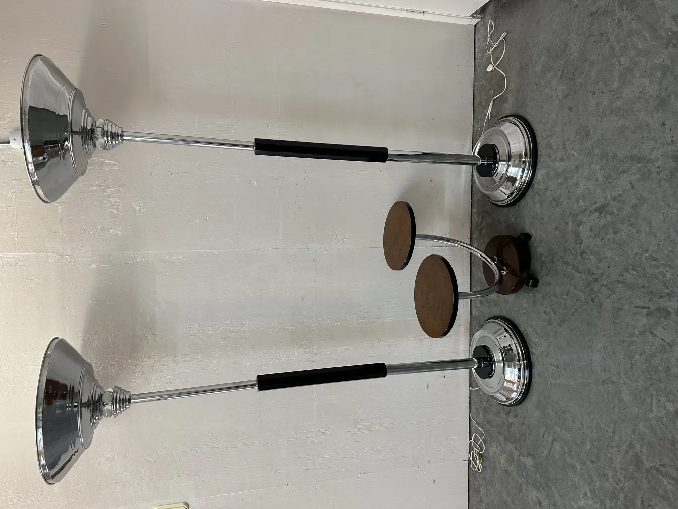 two antique floor lamps with chrome bases in a light room