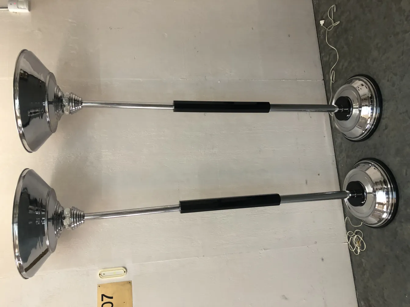 View of two antique floor lamps in a neutral setting