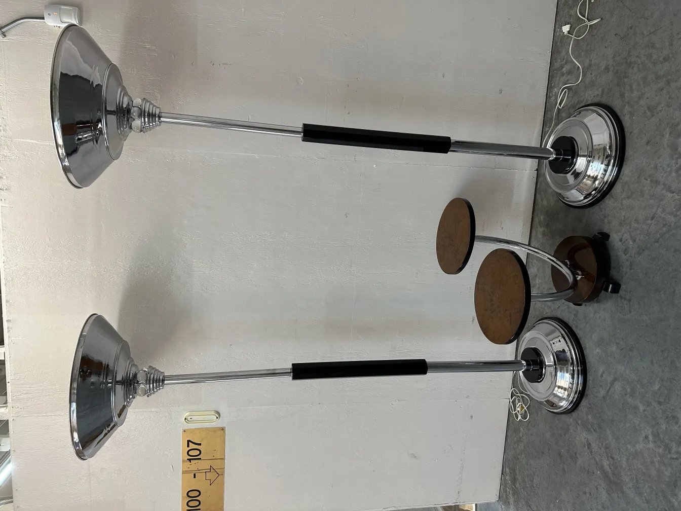 Set of 2 antique floor lamps with silver shades and shiny bases.