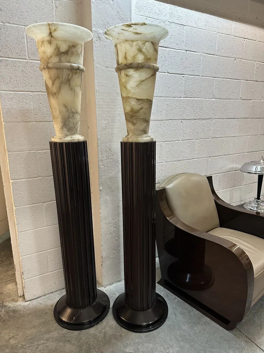 Duas poltronas antigas em um ambiente elegante, com detalhes decorativos e um estilo marcante na sala.