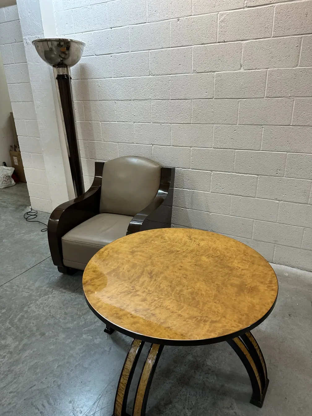 Mesa de centro antiga com tampo redondo e pernas elegantes em um ambiente moderno.