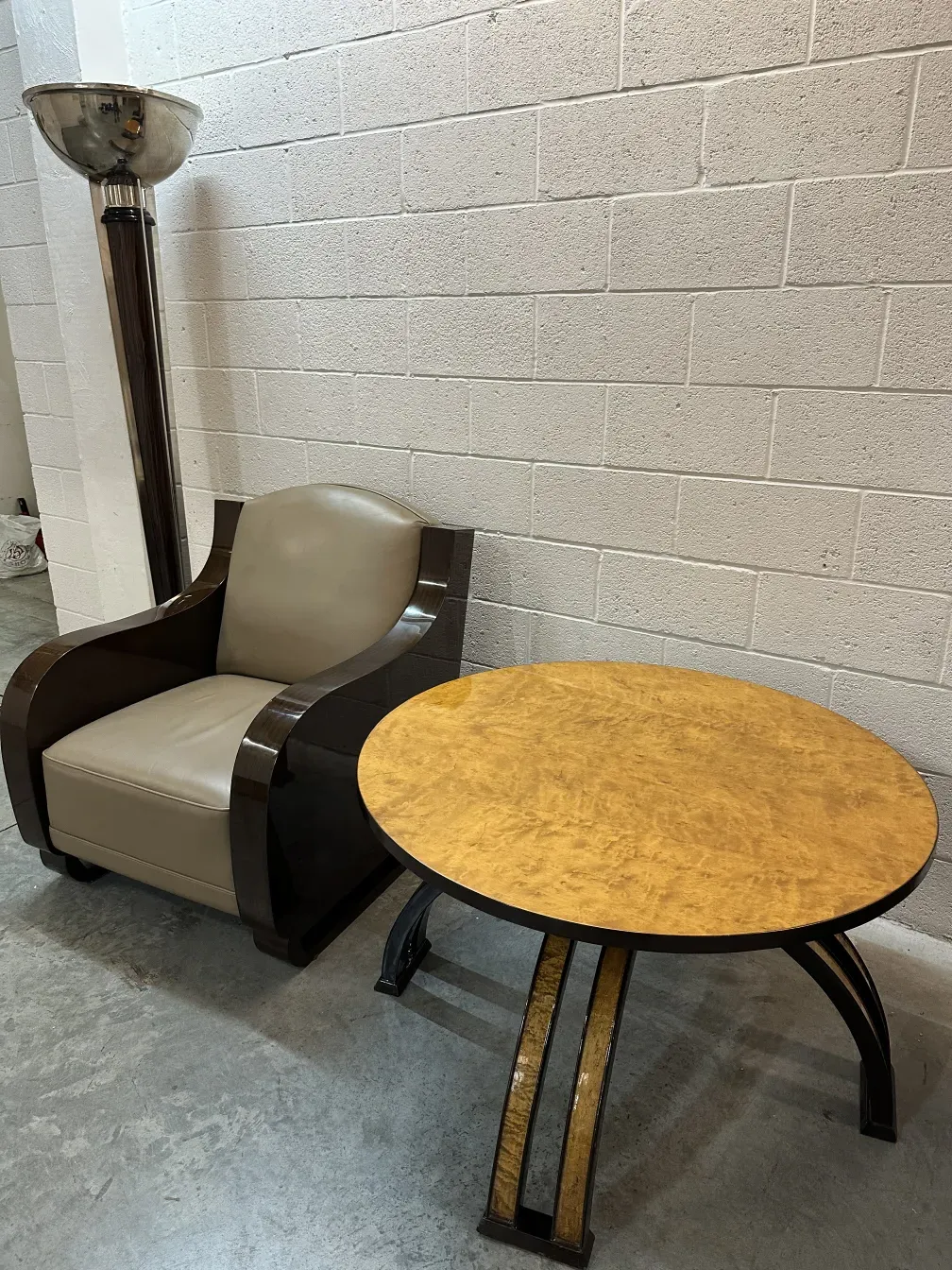 mesa de centro antiga redonda com detalhes decorativos, acompanhada de uma lâmpada moderna