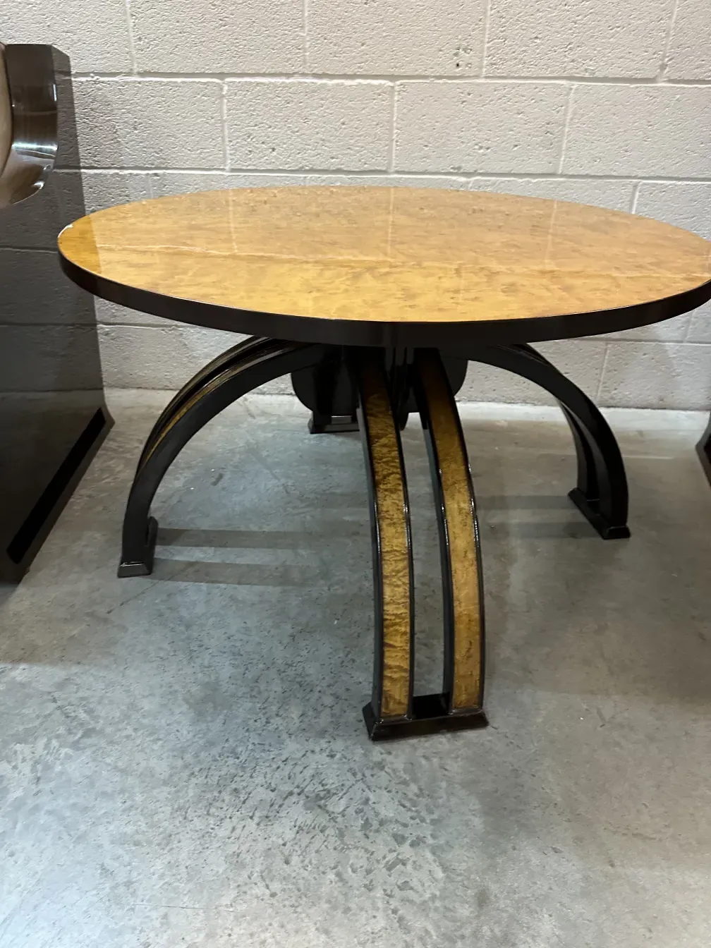 mesa de centro antiga com design circular e pernas elegantes, em um ambiente neutro