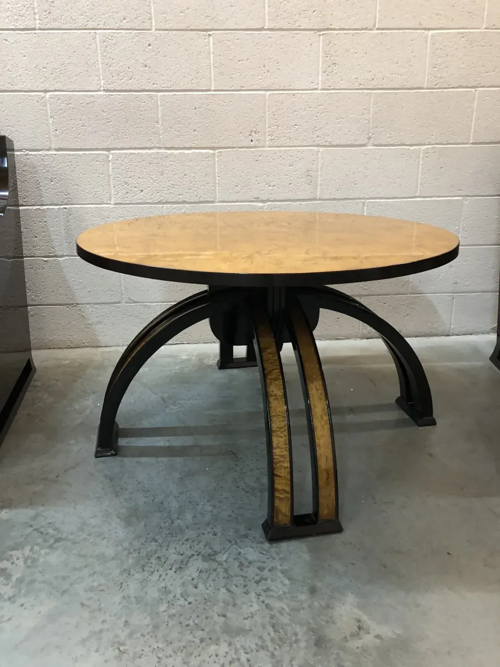 Mesa de centro antiga com forma oval e pernas curvas.