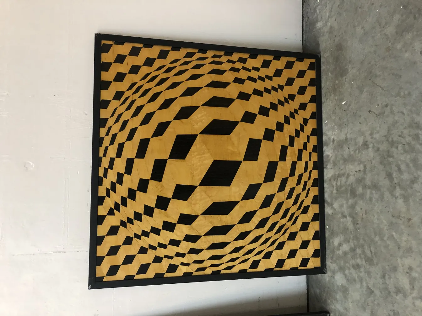 Marquetería antigua con patrones geométricos en tonos dorados y negros.