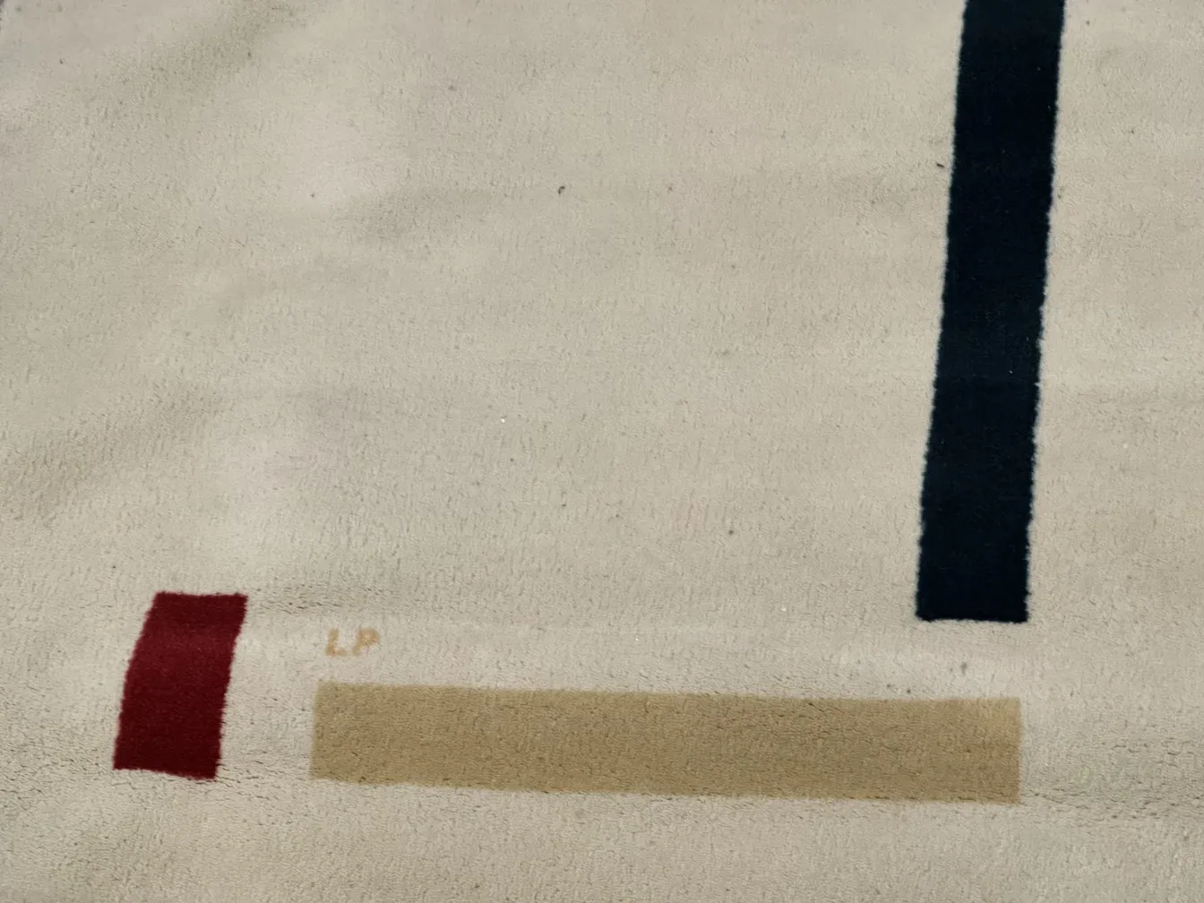 tapis ancien de couleur claire avec détails rouges et bleus