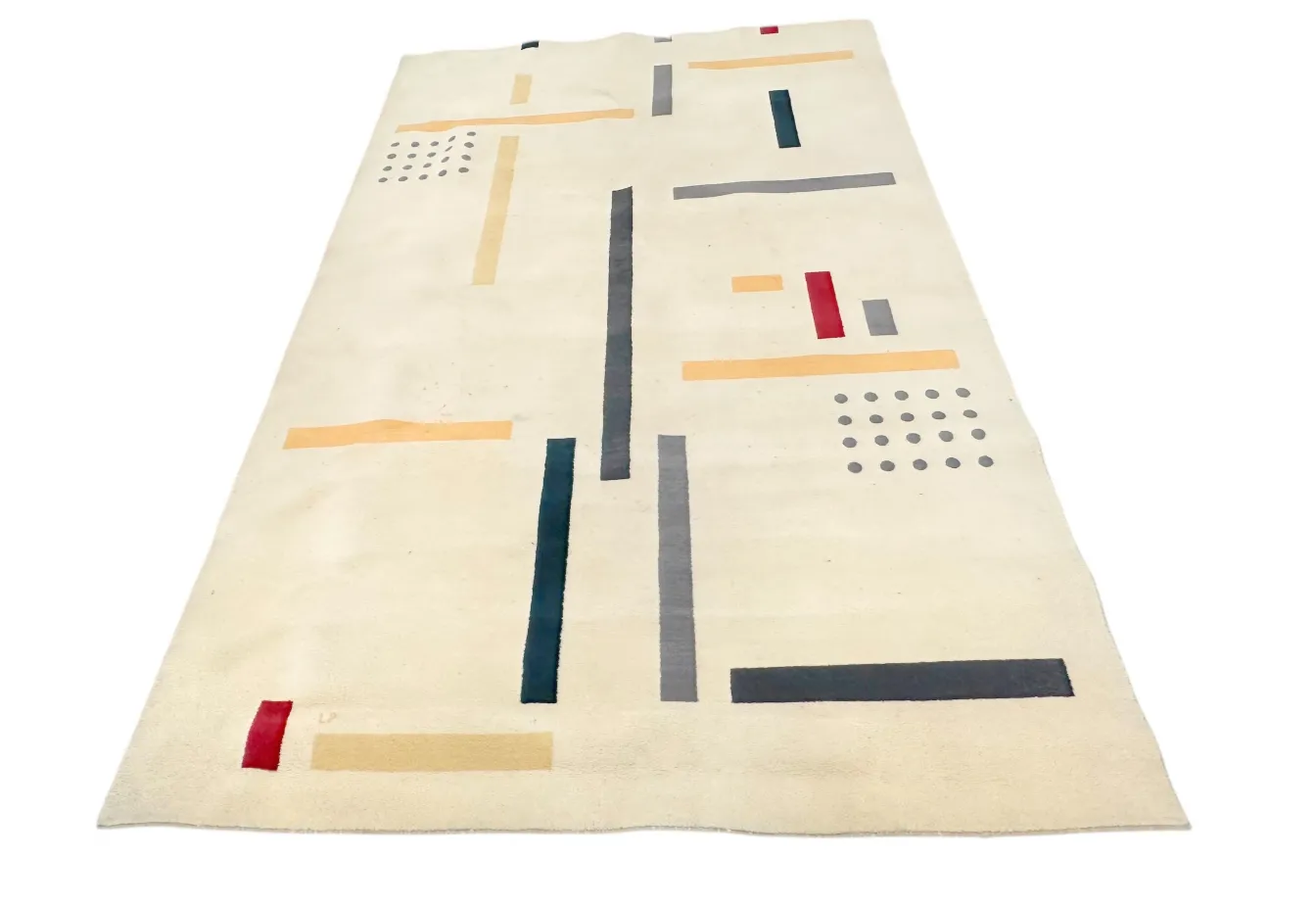 tapis ancien de couleur claire avec des motifs sombres et clairs, décorant un environnement moderne.