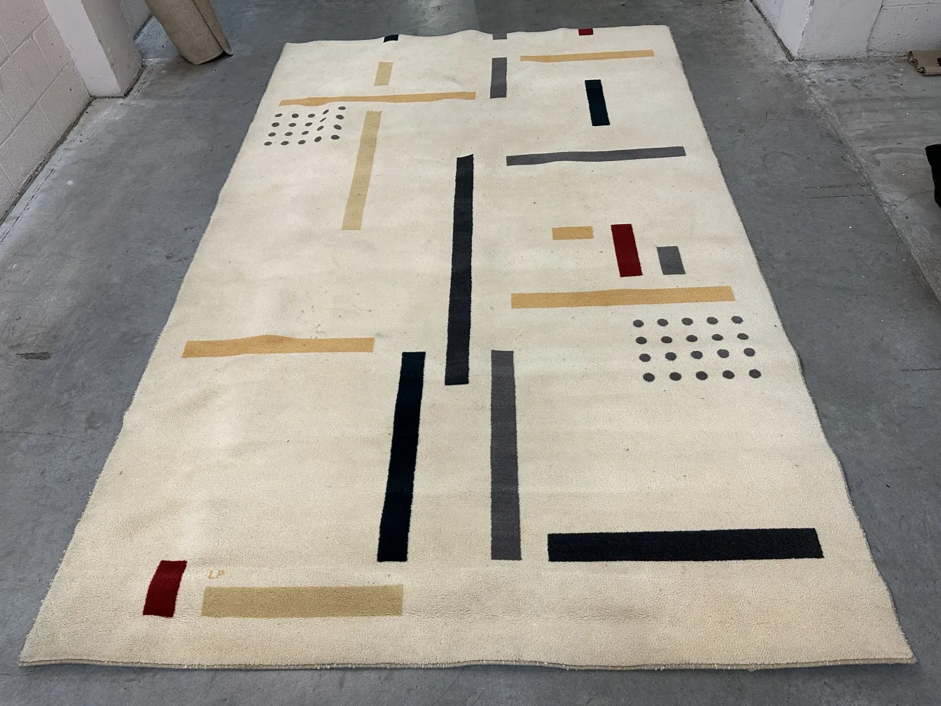 antiker Teppich in hellen Farben mit dunklen und hellen geometrischen Mustern in einer modernen Umgebung