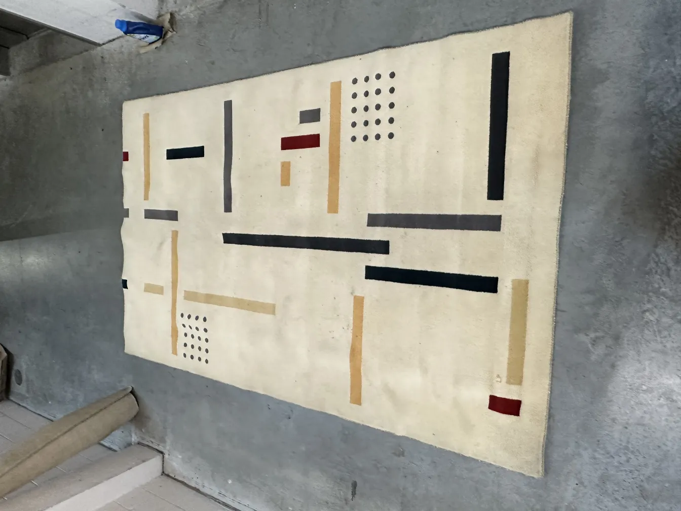 alfombra antigua con diseño geométrico en fondo claro