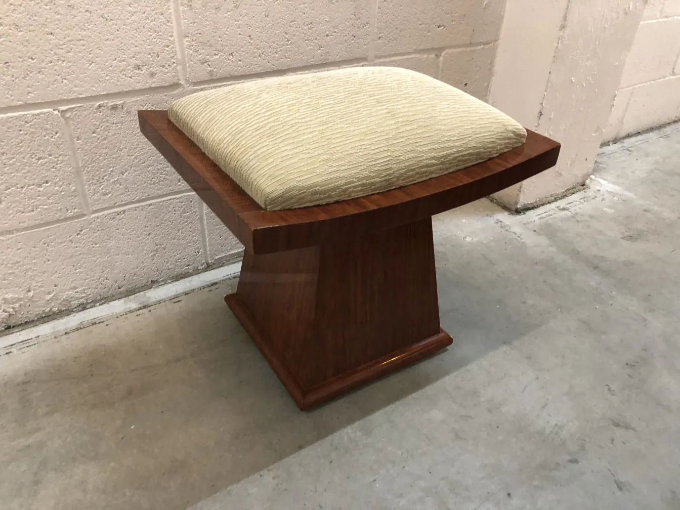 banqueta antigua con cojín claro, elegantemente diseñada