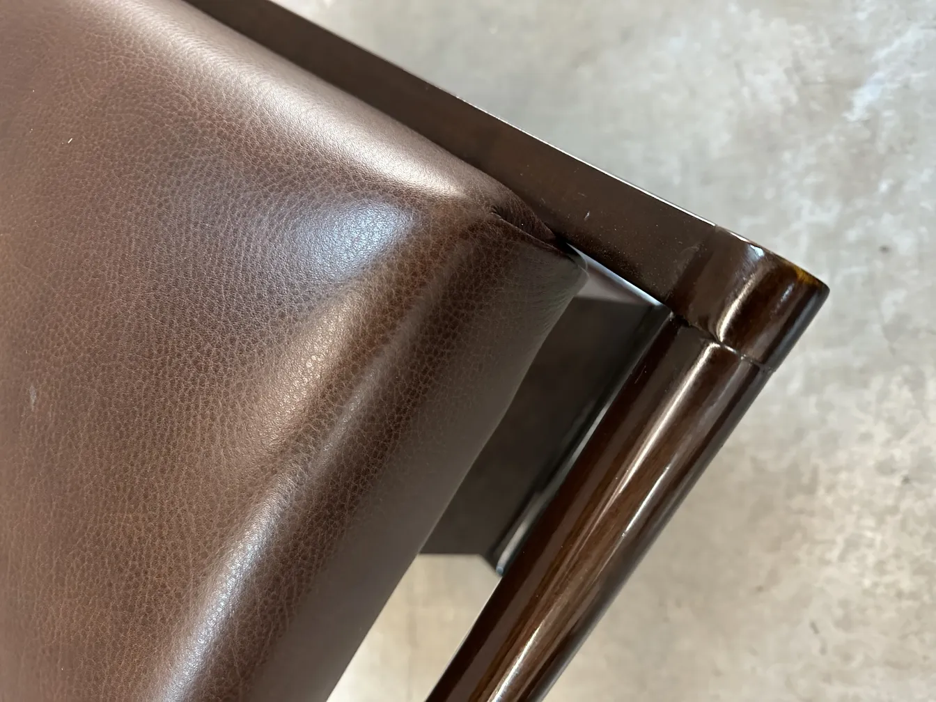 antique stool with brown upholstery and elegant details