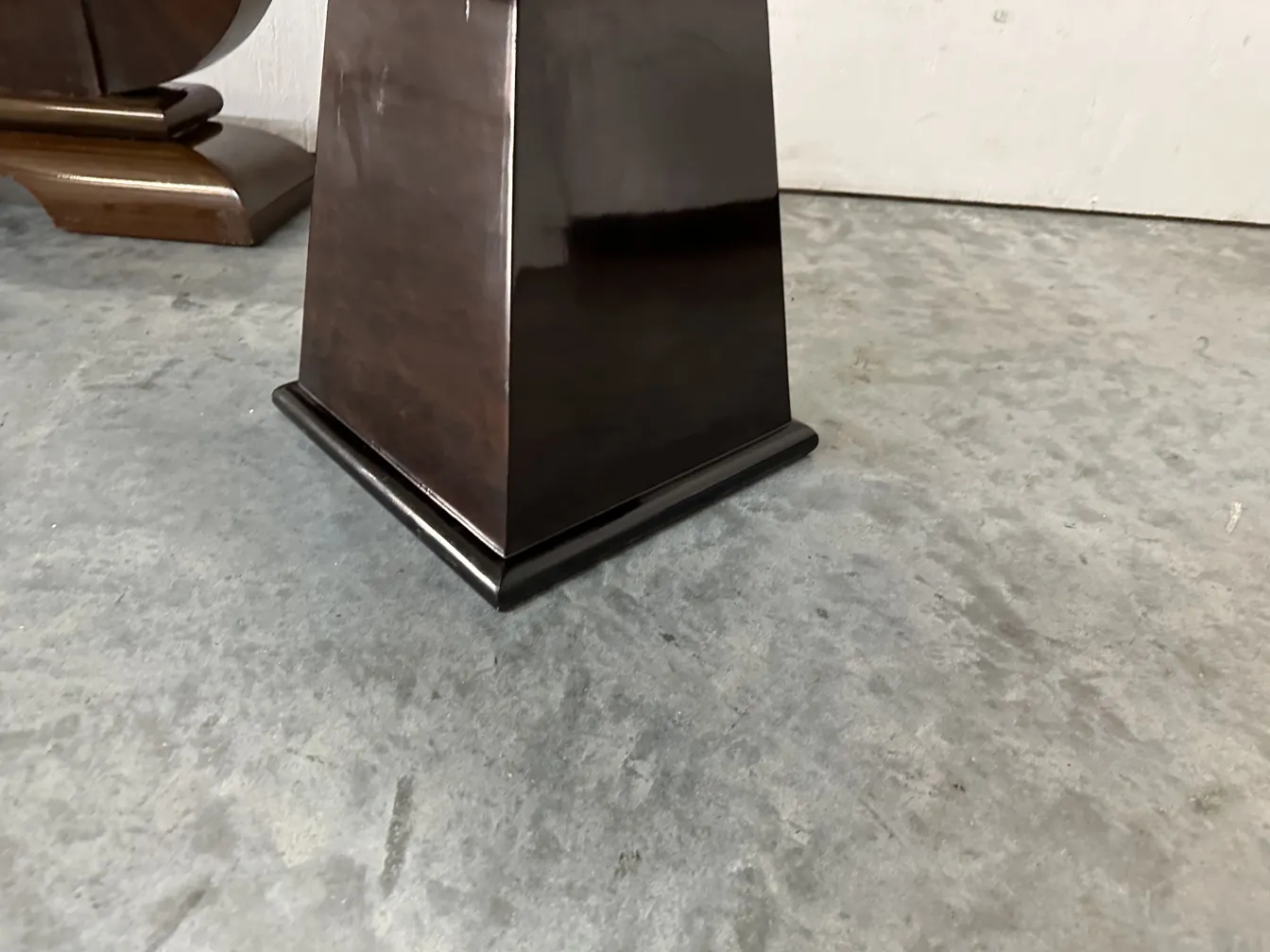 Vue d'un tabouret ancien avec une base carrée.