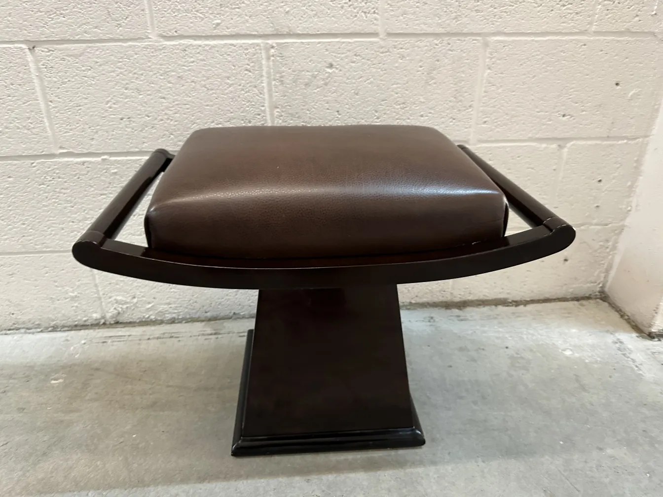 Tabouret ancien avec rembourrage stylé et design élégant, fond neutre.