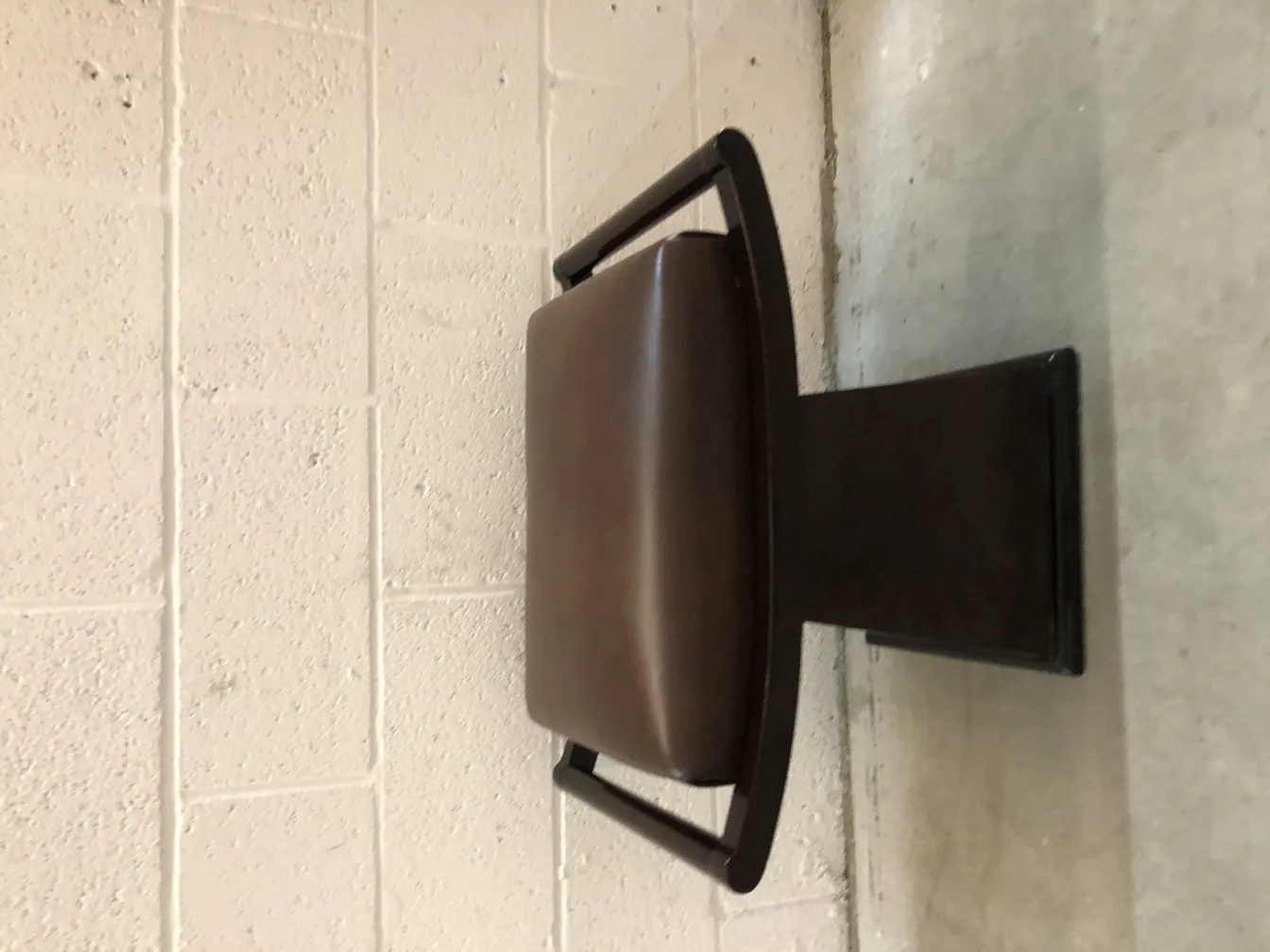 sgabello antico con rivestimento scuro e struttura moderna