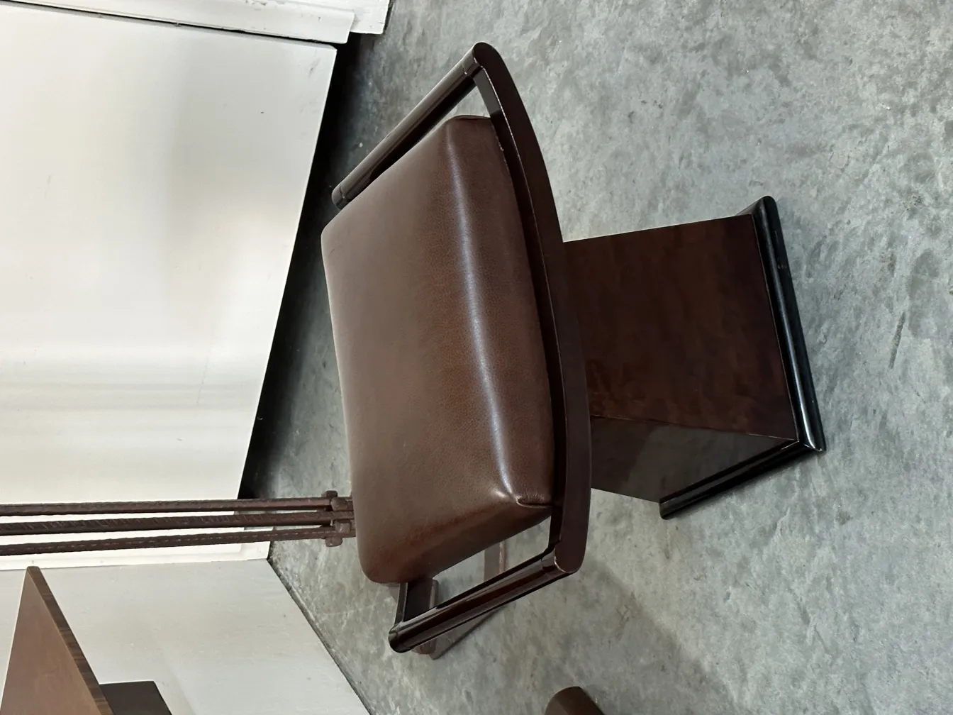 sgabello antico marrone con schienale e design elegante in ambiente neutro