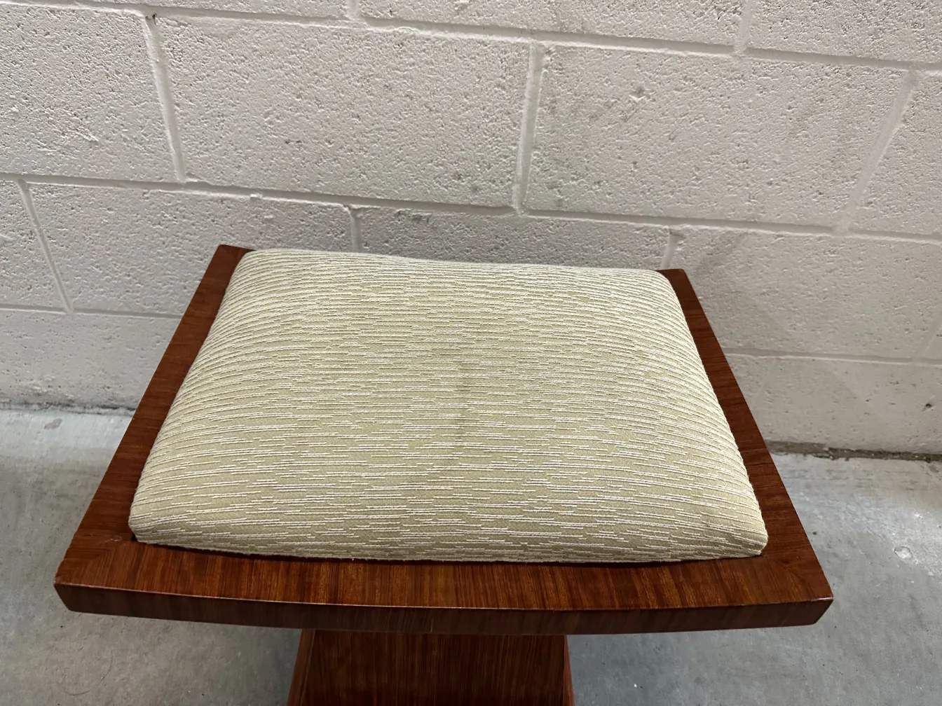 Tabouret ancien avec coussin dans un cadre simple