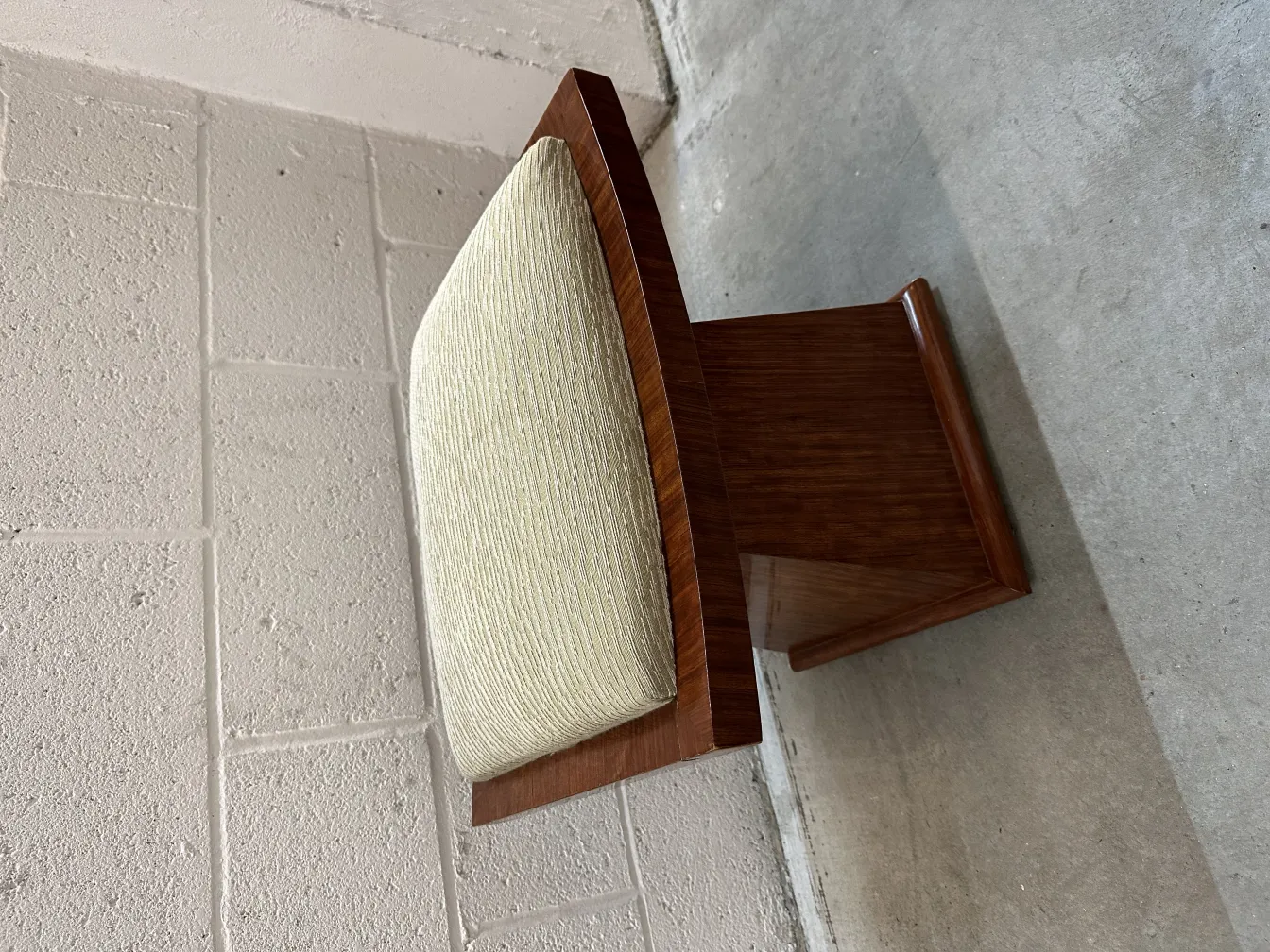 antik hocker mit hellem kissen in neutraler umgebung