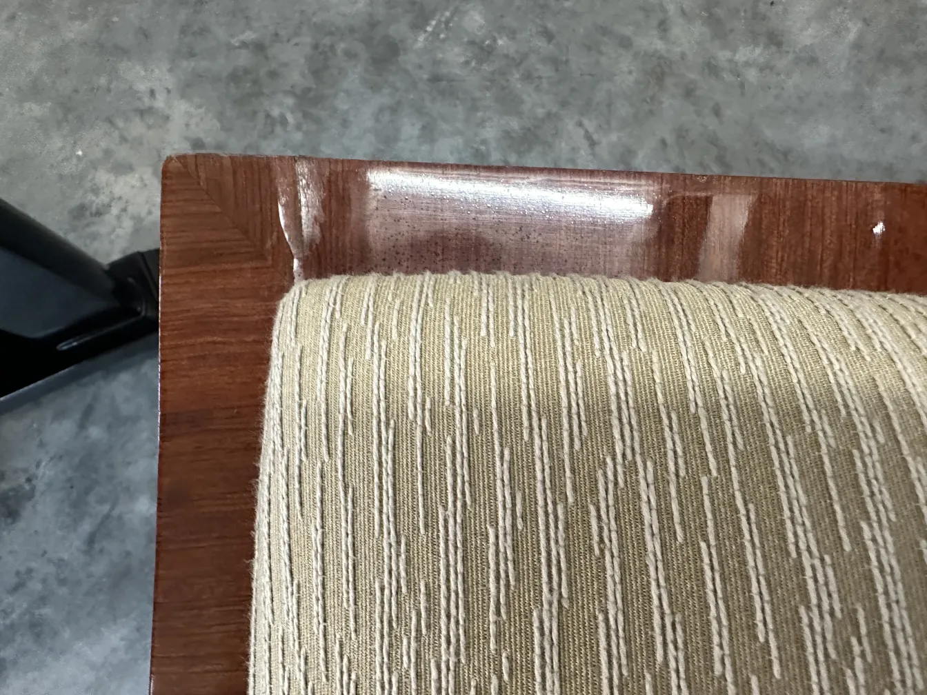 Sgabello antico con rivestimento chiaro e forme morbide, in un ambiente elegante.