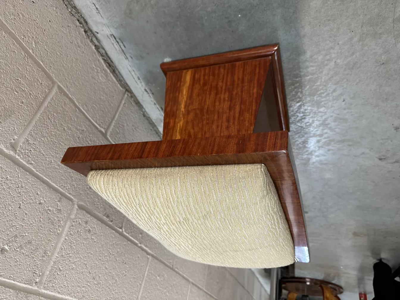 antiker Hocker mit gepolstertem Sitz in eleganter Umgebung