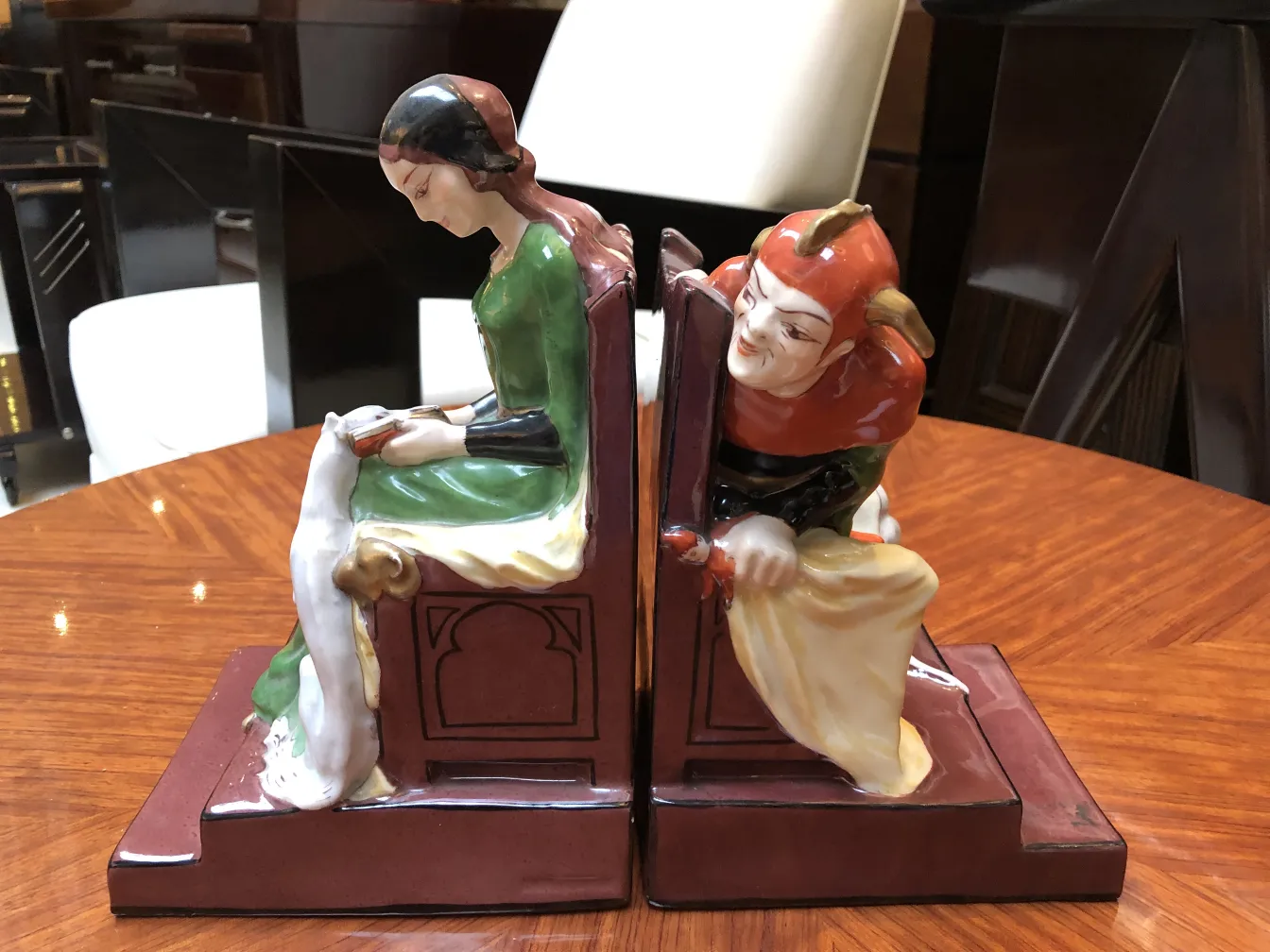 Serre-livres anciens avec des figures élégantes d'Aladin et un personnage, embellissant l'espace.