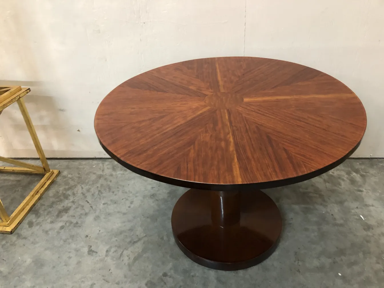 Antique round small table with wood pattern, simple ambient context.