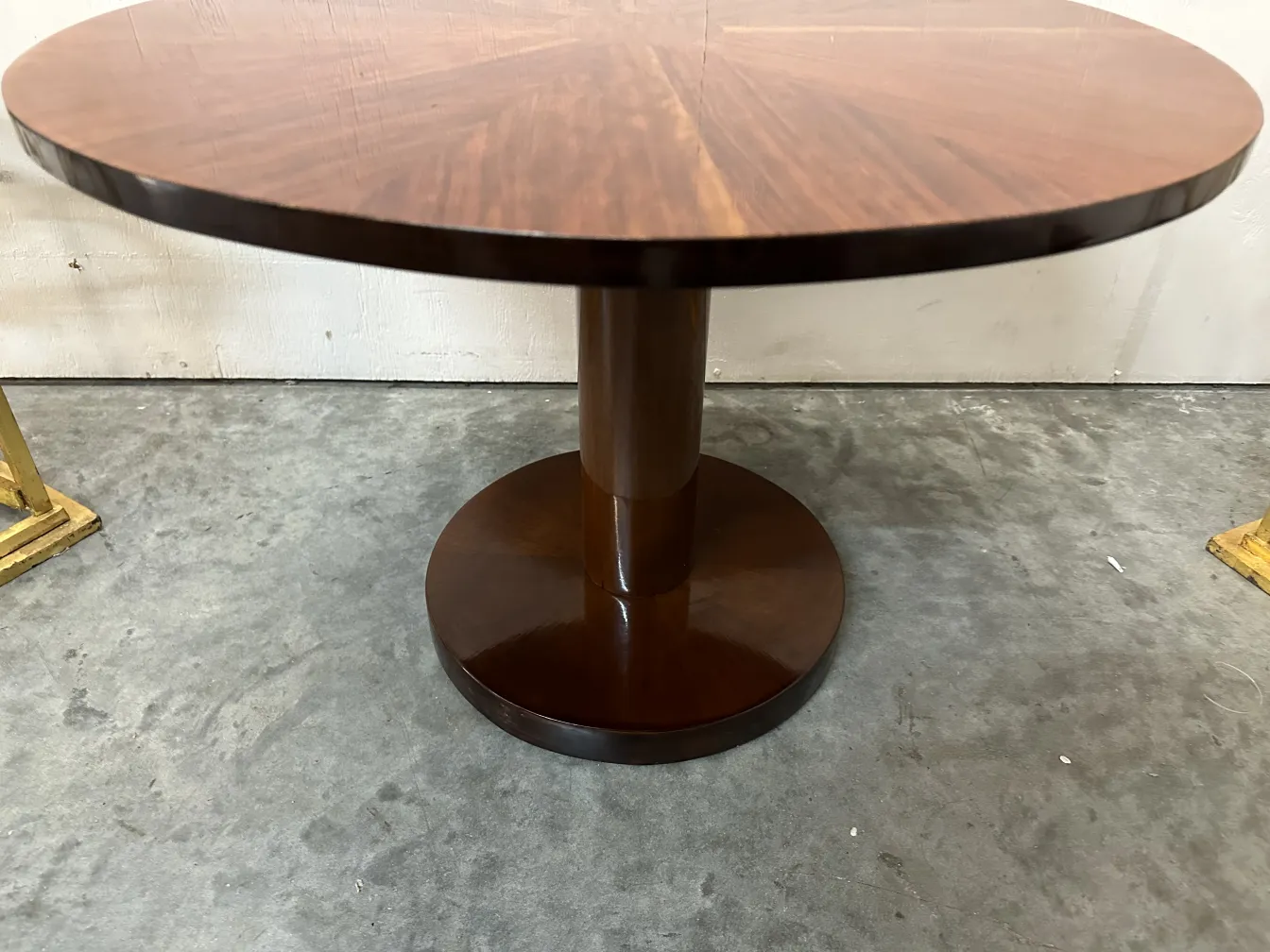 small antique round table with a circular base in a light setting