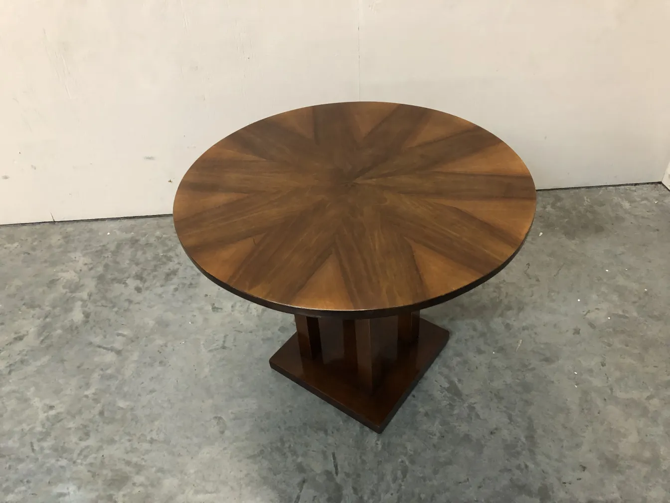 Mesinha antiga redonda com design na parte superior.