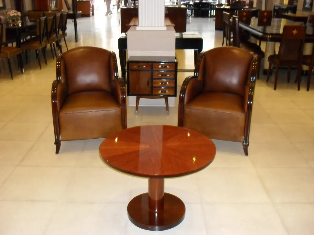 petite table ancienne dans un salon avec fauteuils marron