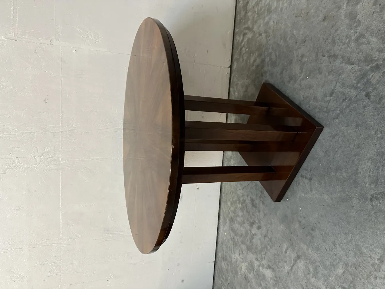 Petite table ancienne ronde avec pieds au design classique, fond neutre.