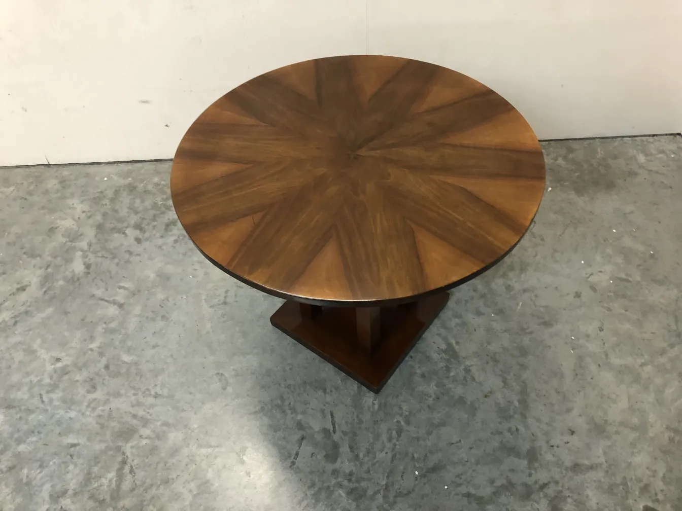 ancienne petite table ronde avec un joli design sur le dessus, dans un environnement neutre