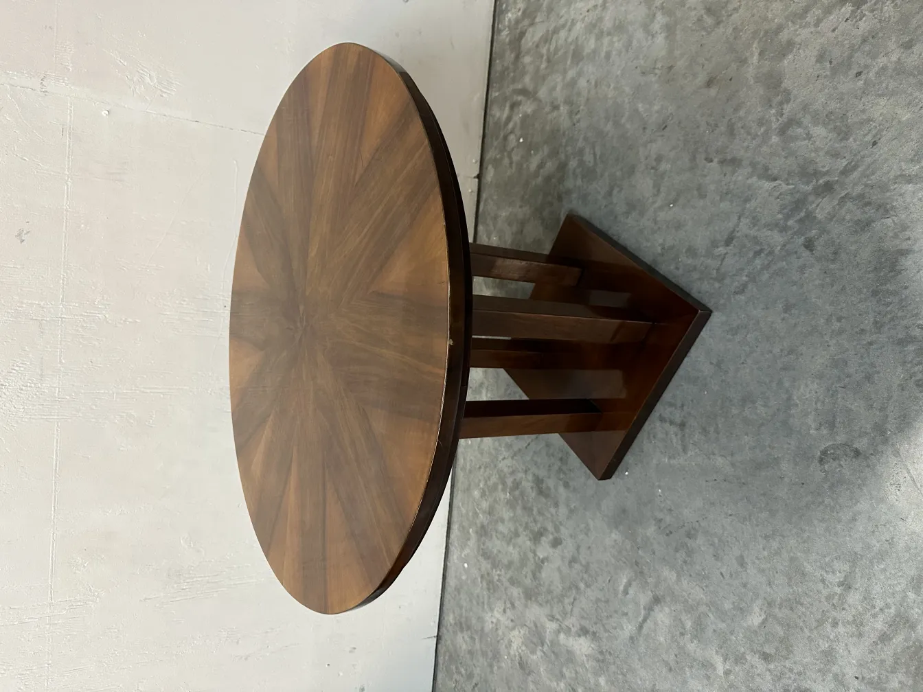 Antique round small table with an elegant base on a light background.