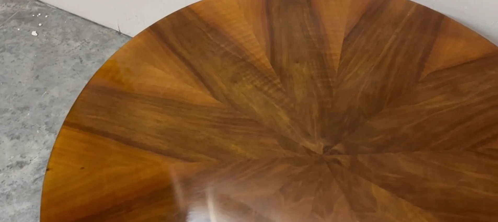 Antique round table with detailed wooden design, complemented by a modern environment.