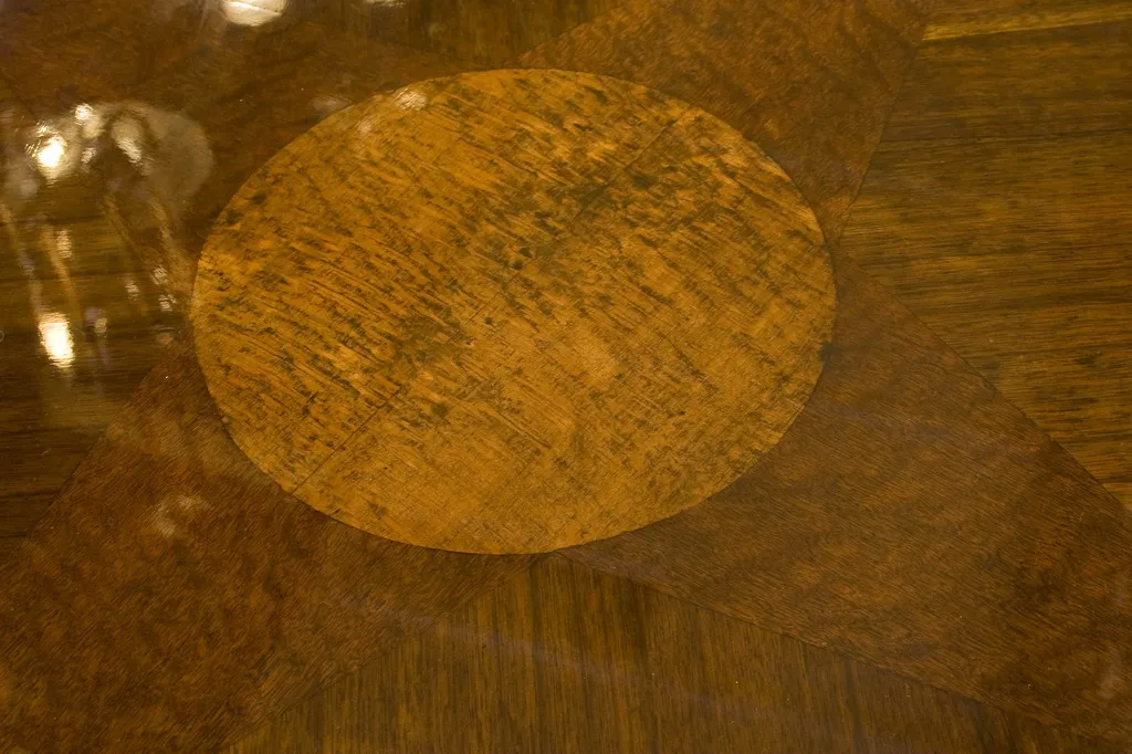 Small antique table with circular design on its surface.