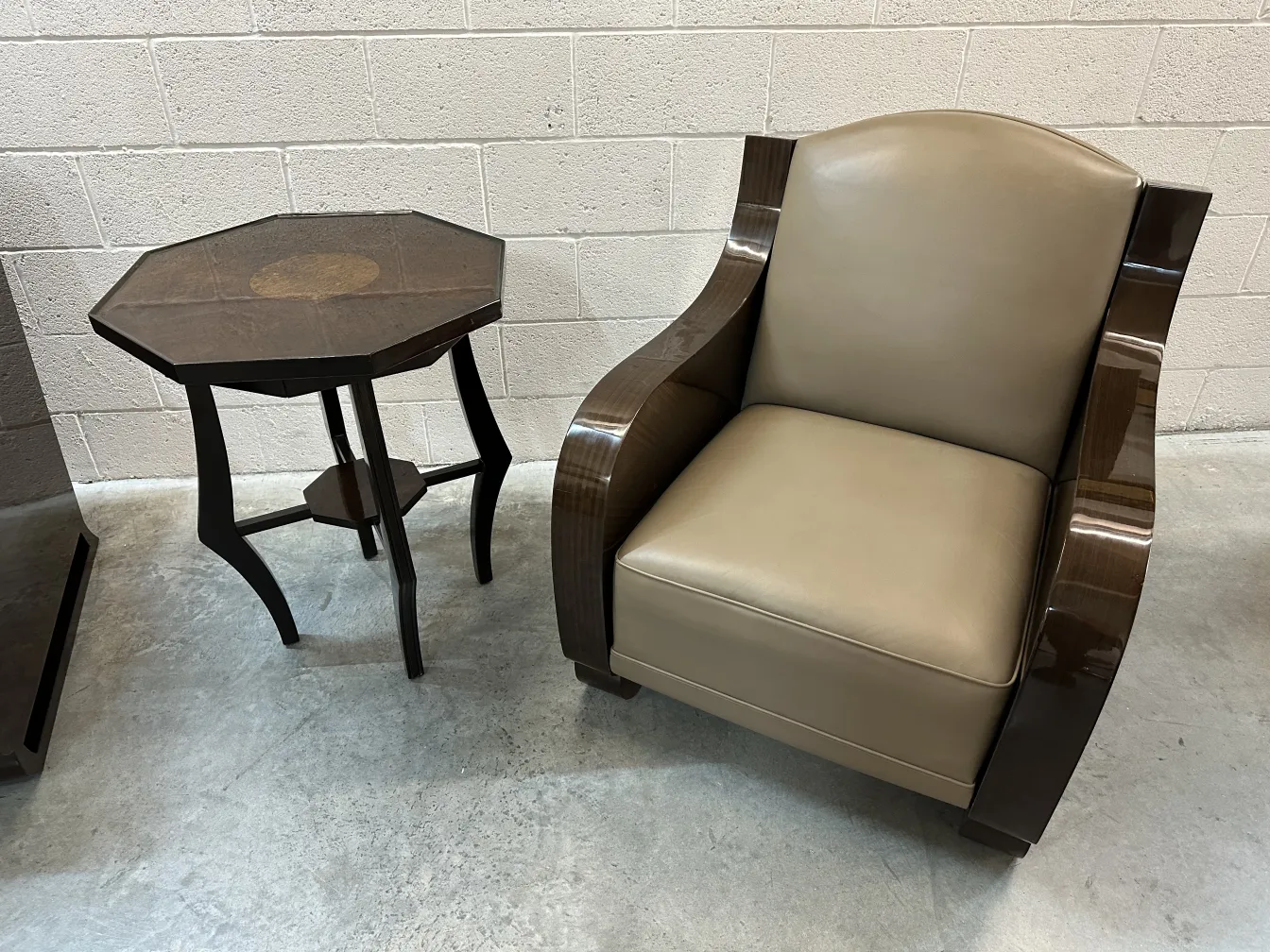 Petite table antique de forme octogonale à côté d'un fauteuil moderne