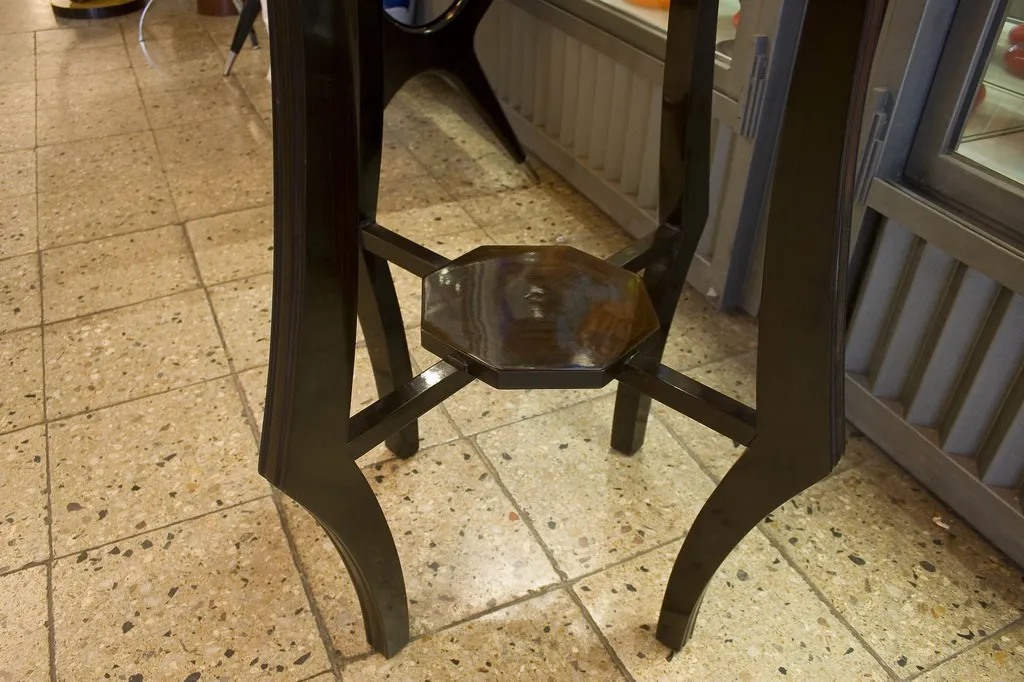 Mesinha octagonal antiga com pernas elegantes em um ambiente acolhedor