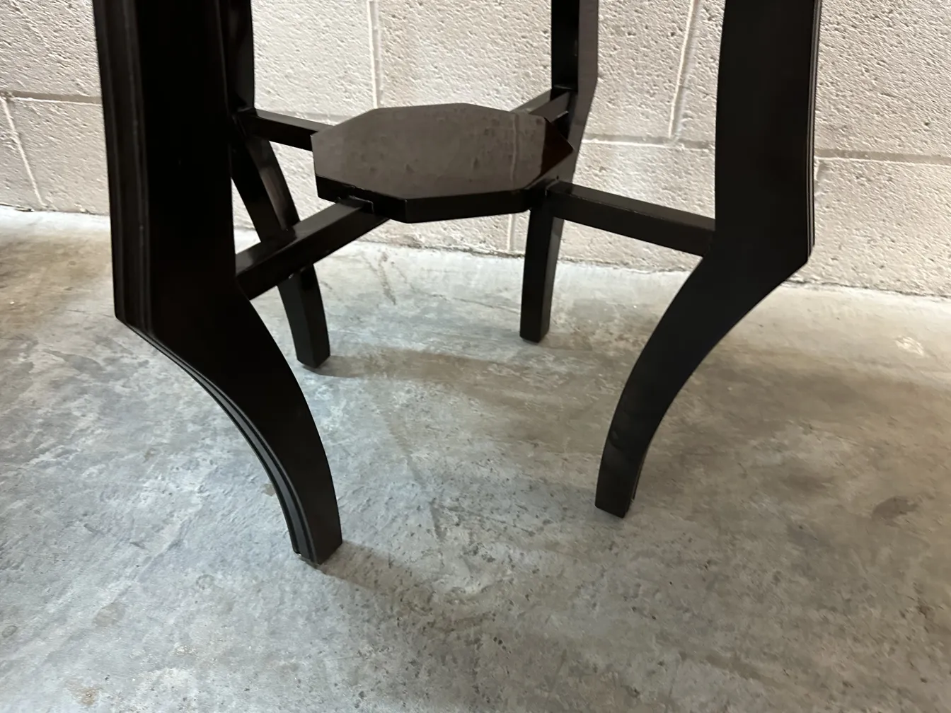 ancienne petite table noire avec des pieds courbés dans un cadre classique