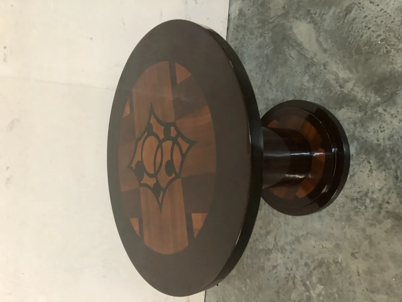 antique round table with intricate top design and circular base