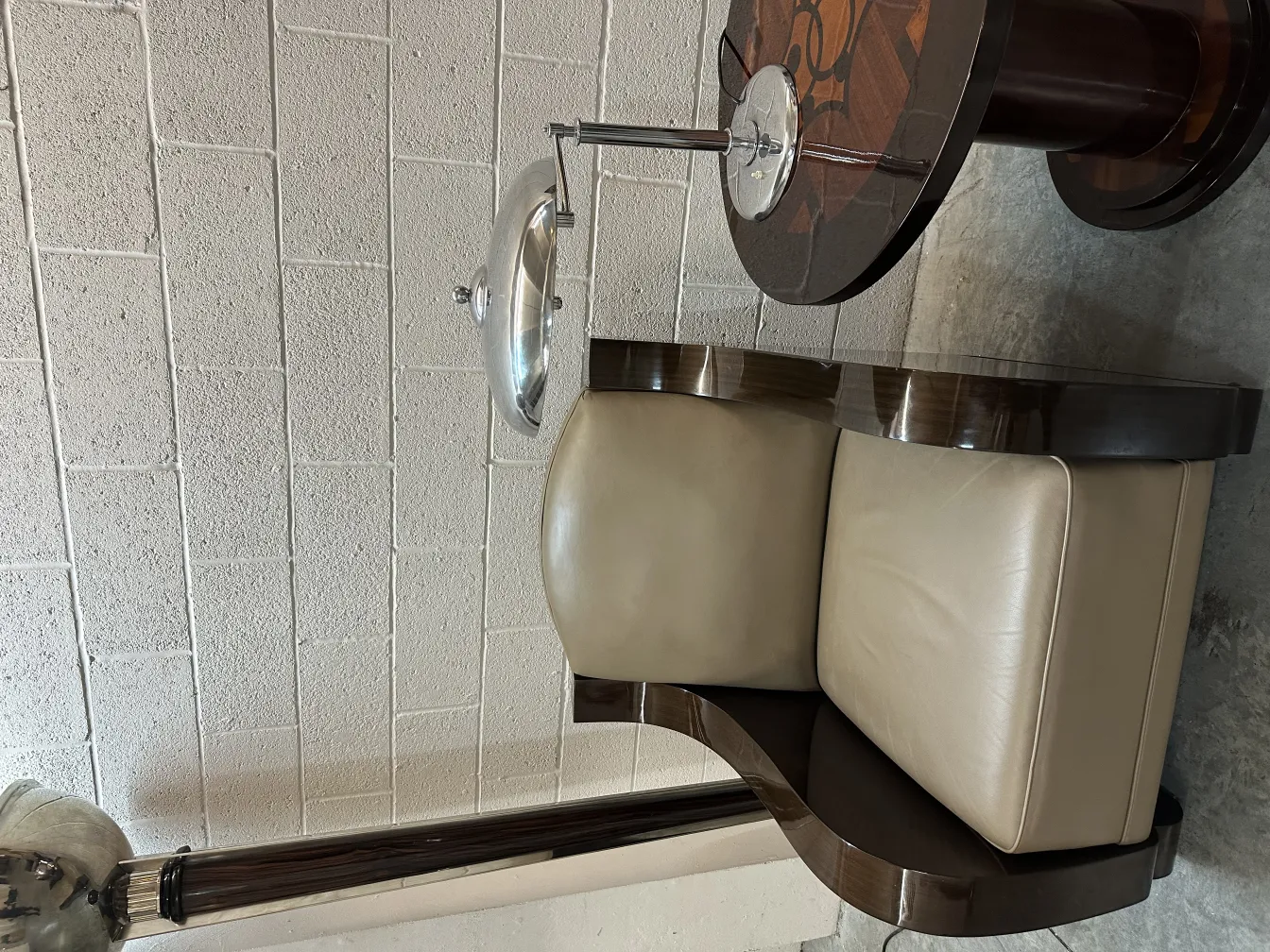 Decorative antique small table next to a light-colored chair in a modern room.
