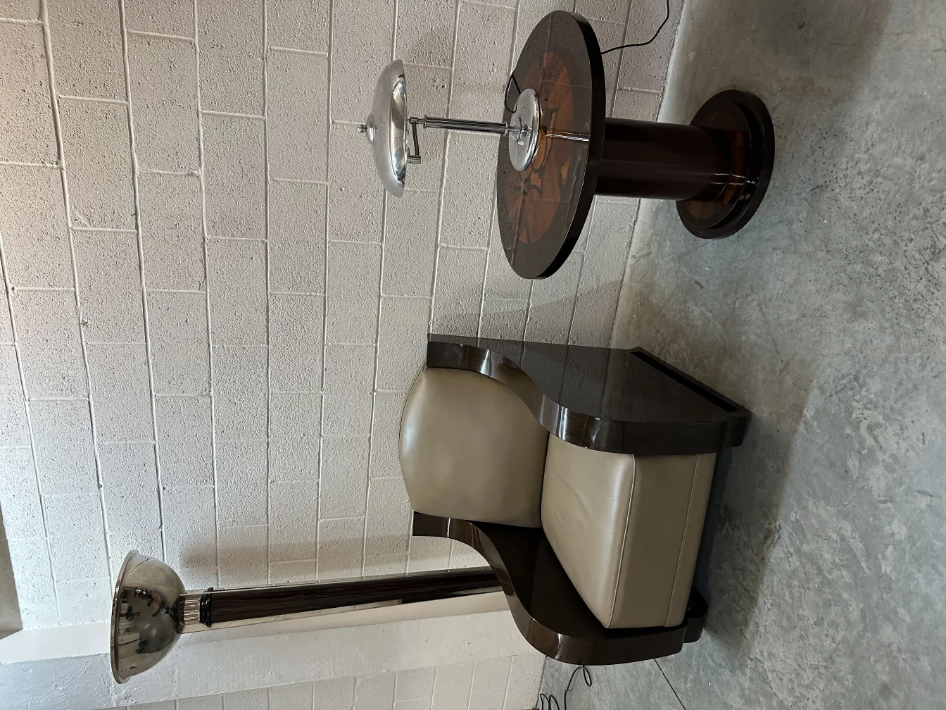 Tavolino antico con design attraente e dettagli eleganti, in un ambiente accogliente. Accanto, una lampada moderna.