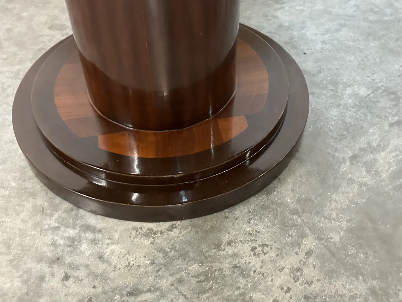 detail of the base of an antique small round table with a shiny finish.