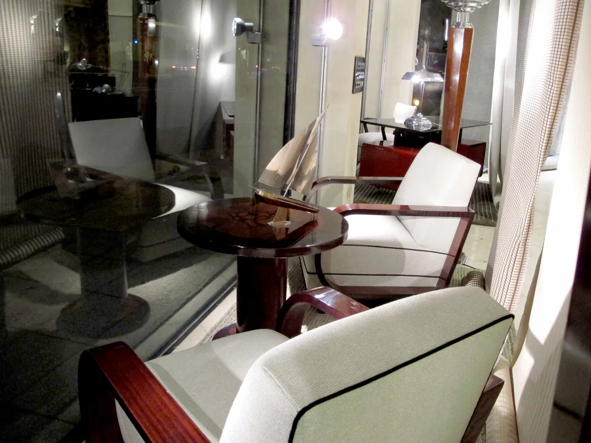 طاولة قديمة صغيرة بجانب كراسي في بيئة مريحة.