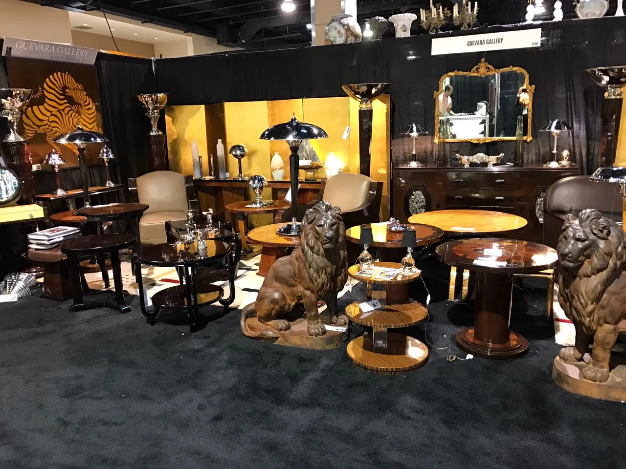 Mesita antigua con un diseño decorativo, rodeada de otros muebles y elementos de ambiente.